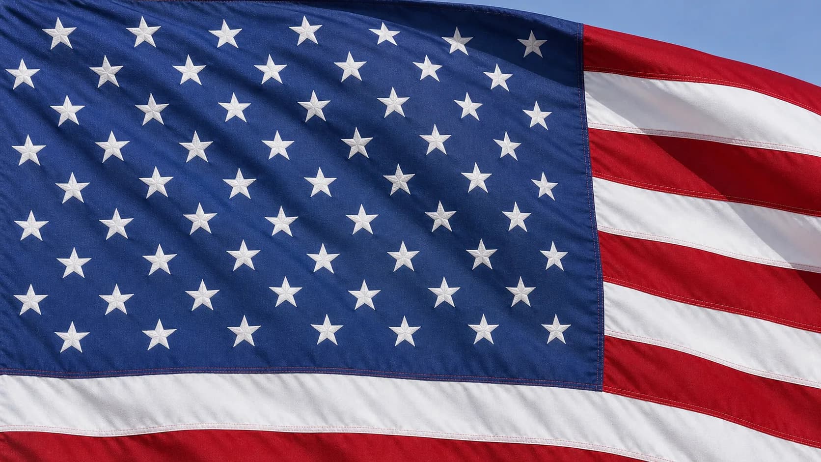 A close view of the blue canton of the American flag, filled with rows of white stars.